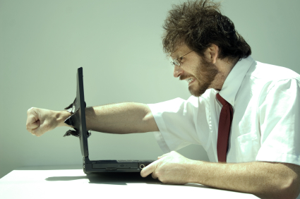 Frustrated man punching computer